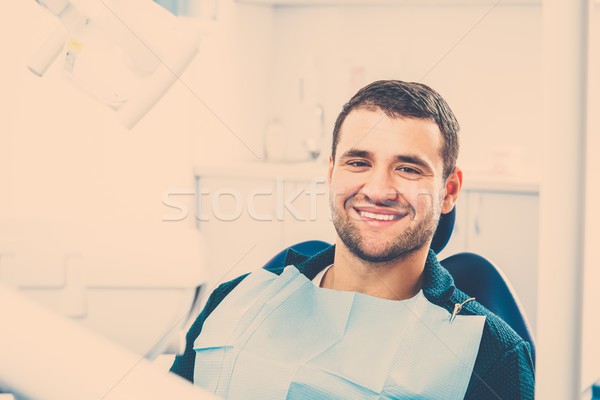 Smiling young man at dentist's surgery Stock photo © Nejron