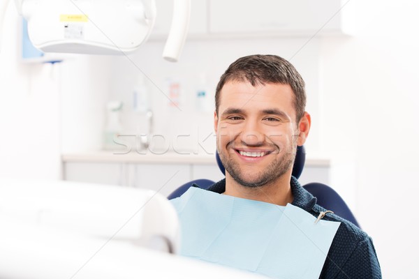 Smiling young man at dentist's surgery Stock photo © Nejron