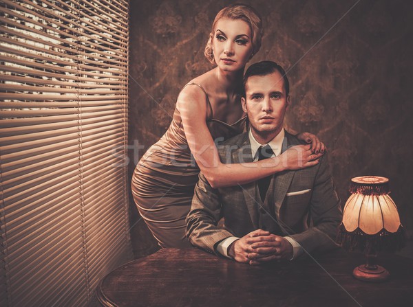 Stock photo: Well-dressed retro couple behind table