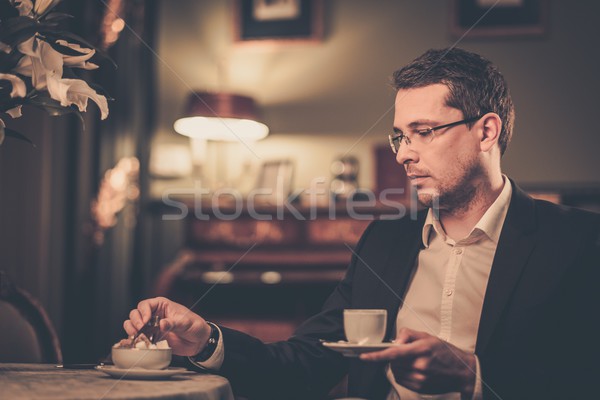 Stock photo: Middle-aged with cup of coffee in luxury vintage style interior 