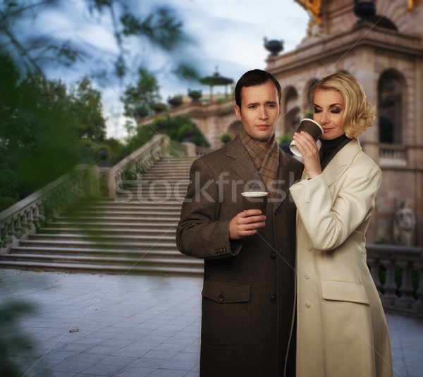 Elegant couple outdoors with cups of hot drink Stock photo © Nejron