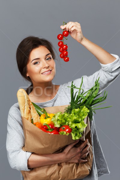 Smiling  brunette woman with grocery bag full of fresh vegetables and cherry tomatoes  Stock photo © Nejron