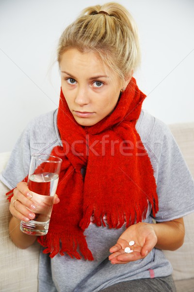 Sick young blond woman with pills and glass of water Stock photo © Nejron