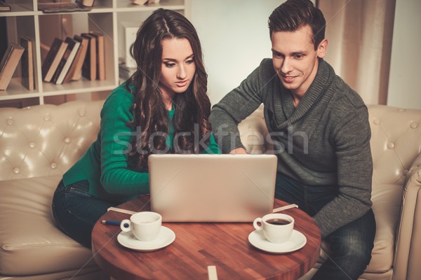 Young couple with laptop and coffee behind table Stock photo © Nejron