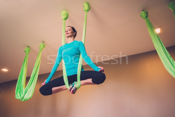 Young woman performing antigravity yoga exercise  Stock photo © Nejron