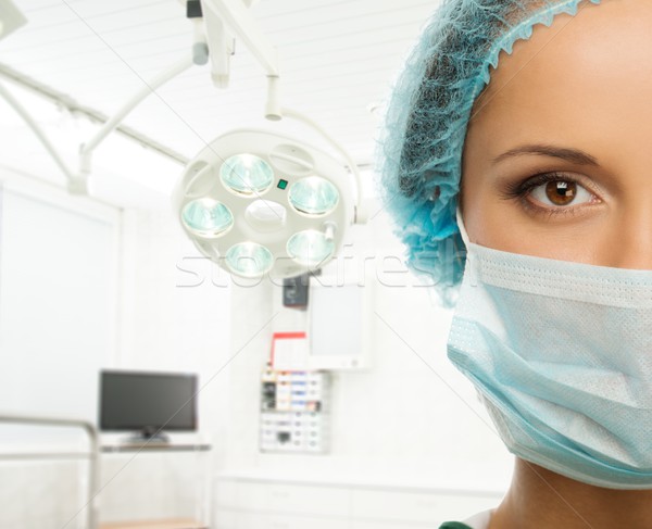 Young woman doctor in cap and face mask in surgery room interior Stock photo © Nejron