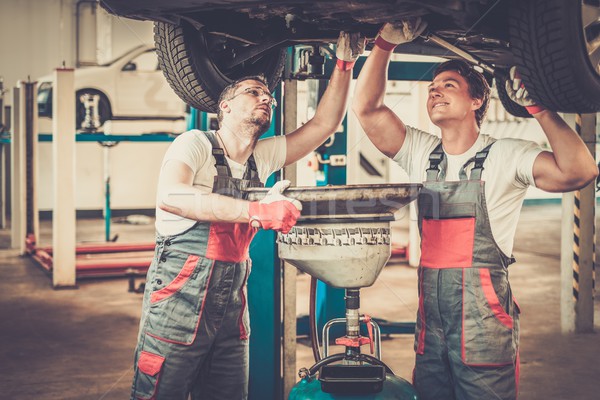 Two mechanics changing oil  in a car workshop Stock photo © Nejron