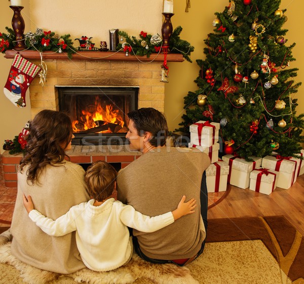 Family near fireplace in Christmas decorated house interior with gift box Stock photo © Nejron