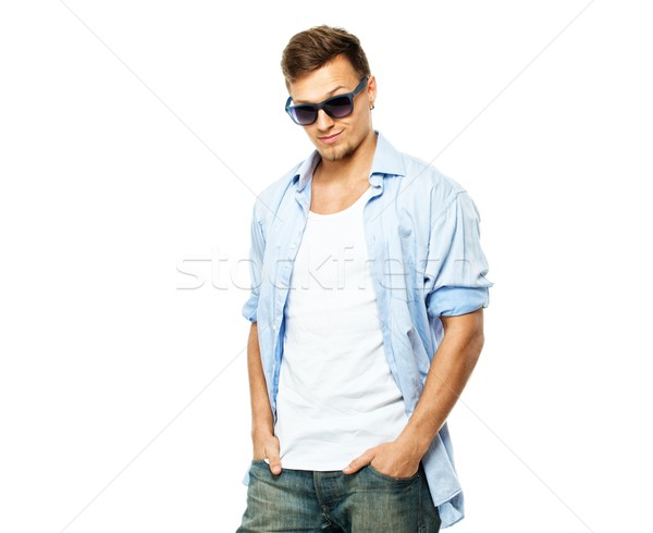 Stylish man in blue shirt and jeans wearing sunglasses isolated on white Stock photo © Nejron