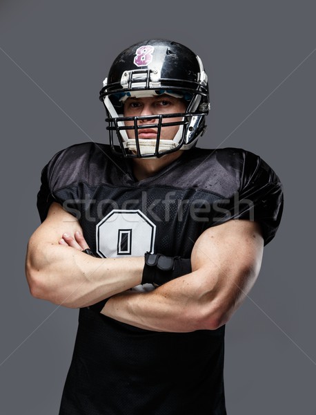 Stock photo: American football player wearing helmet and black jersey with number