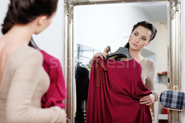 Young woman choosing clothes in a showroom  Stock photo © Nejron
