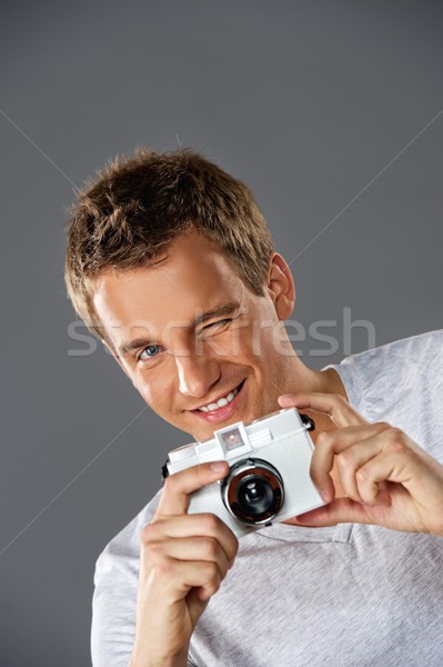 Stock photo: Young man with a photocamera