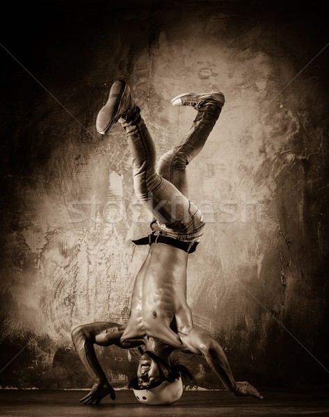 Toned picture of young man with naked torso doing acrobatic movements  Stock photo © Nejron