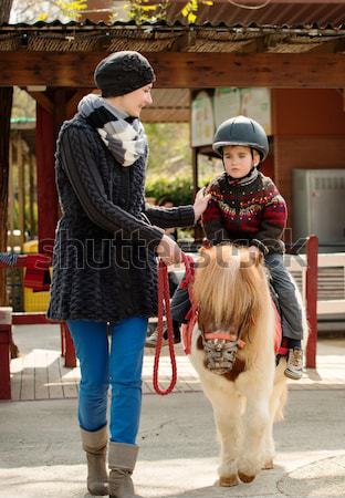 Anya lovaglás fiú póni visel sisak Stock fotó © Nejron