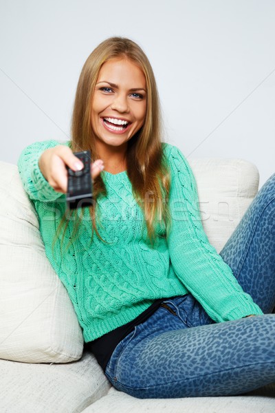 Young beautiful woman on a sofa with remote control  Stock photo © Nejron