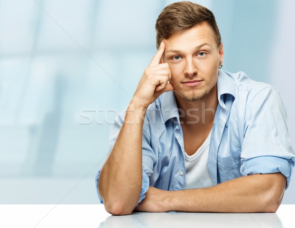 Stylish man in blue shirt with earring on blue background  Stock photo © Nejron