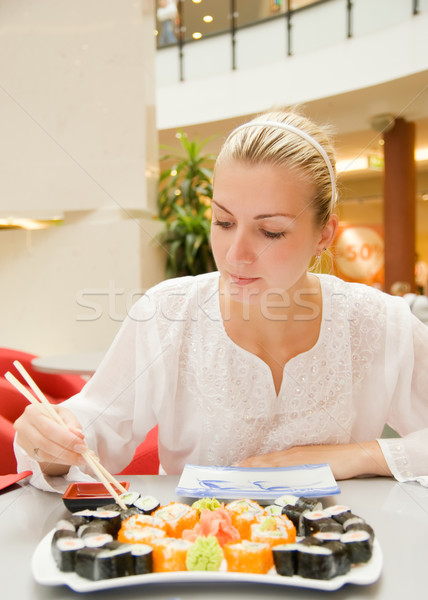 Stock photo: Girl eats sushi in a rastaurant