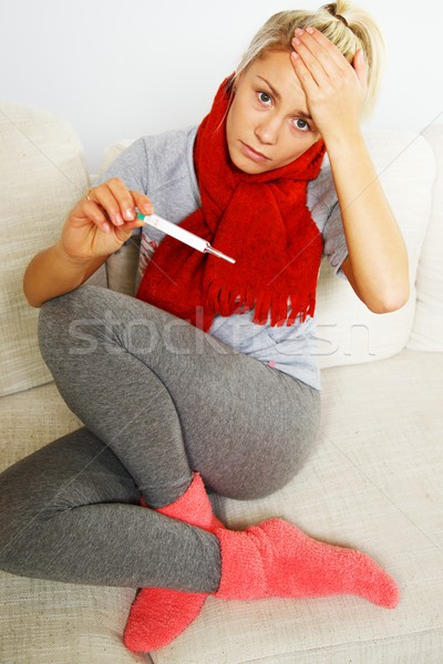 Sick young woman with thermometer at home Stock photo © Nejron