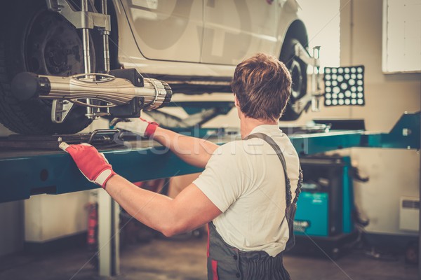 Young serviceman checking wheel alignment  in a car workshop  Stock photo © Nejron