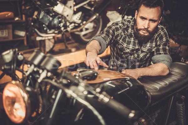 Mechanic building vintage style cafe-racer motorcycle  in custom garage Stock photo © Nejron
