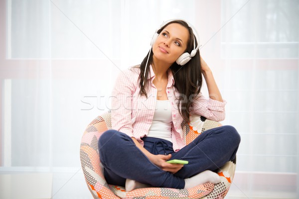 Positive young woman with long hair and blue eyes listens to music Stock photo © Nejron