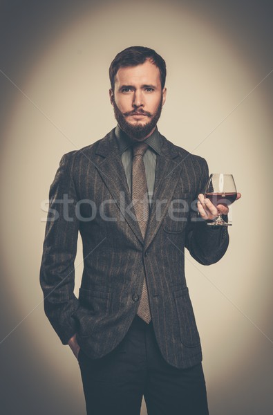 Handsome well-dressed man in jacket with glass of beverage Stock photo © Nejron