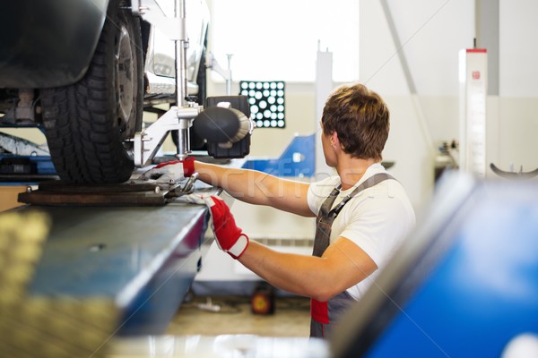 Young serviceman checking wheel alignment  in a car workshop  Stock photo © Nejron