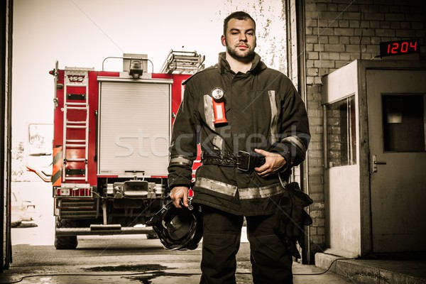 Firefighter against truck in firefighting depot  Stock photo © Nejron