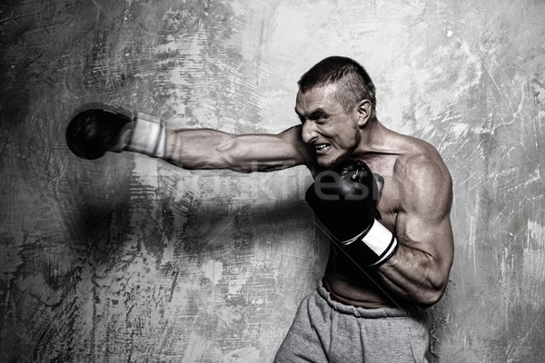 Young man in boxing gloves making punch  Stock photo © Nejron
