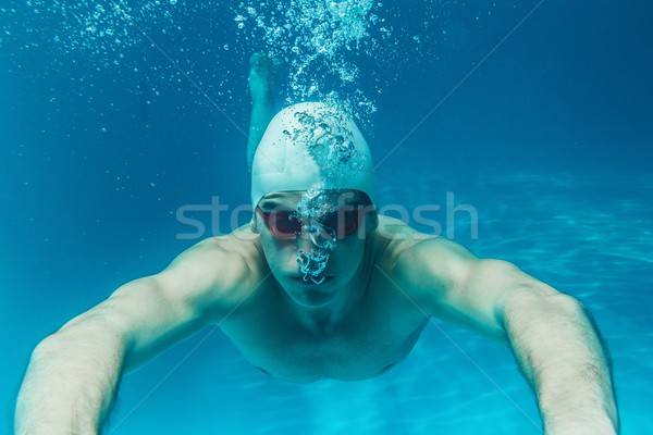 Man in swim cap and googles under water in swimming pool Stock photo © Nejron