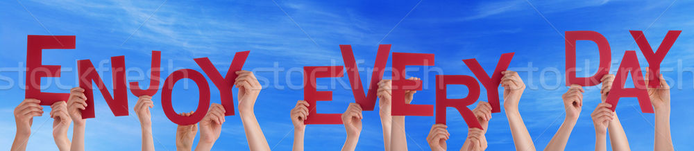 Hands Holding Red Word Enjoy Every Day Blue Sky Stock photo © Nelosa