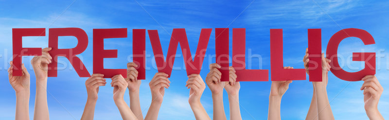 People Holding Straight German Word Freiwillig Means Voluntary B Stock photo © Nelosa