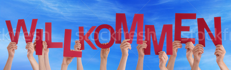 Stock photo: Hand Hold German Willkommen Means Welcome Blue Sky