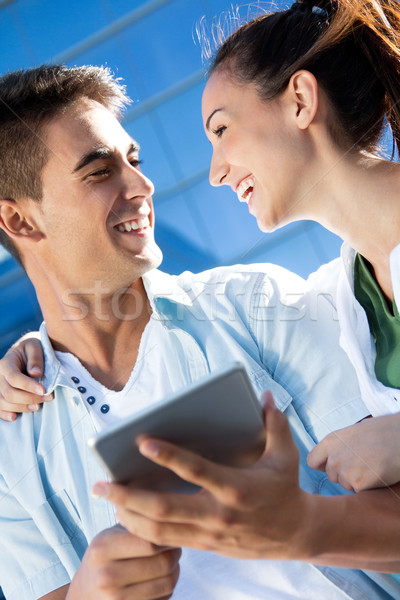 Stock photo: Outdoor portrait of one young couple using a digital tablet