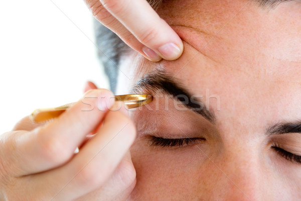 Man removing eyebrow hairs with tweezing. Stock photo © nenetus