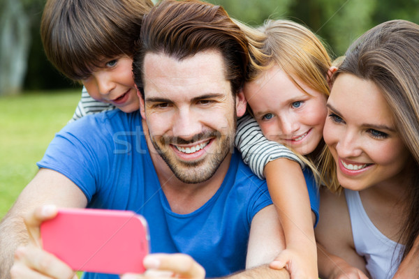 Happy young family taking selfies with her smartphone in the par Stock photo © nenetus