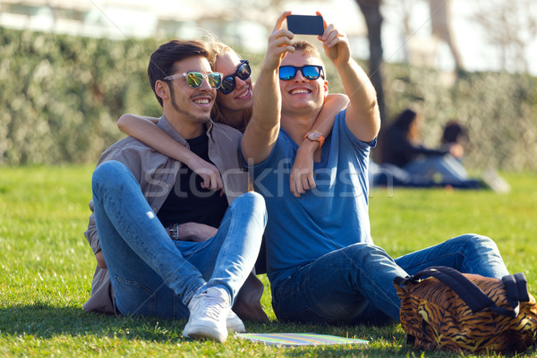 Group of students taking photos with a smartphone in the street. Stock photo © nenetus