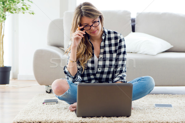 Beautiful young woman using her laptop at home. Stock photo © nenetus