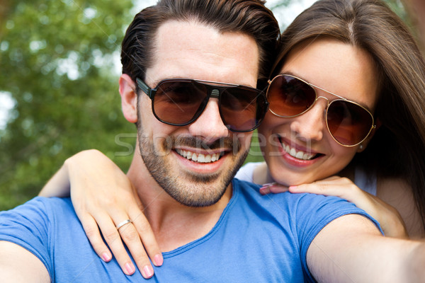 Happy young couple taking selfies with her smartphone in the par Stock photo © nenetus