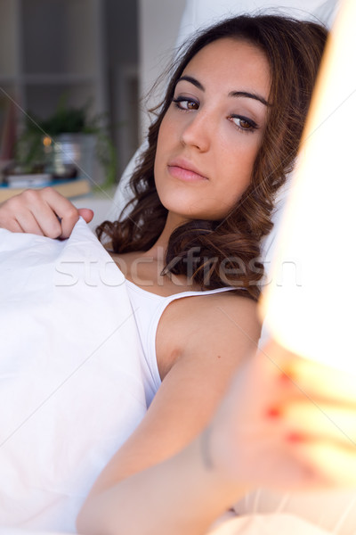 Beautiful young woman turning off the lamp. Stock photo © nenetus