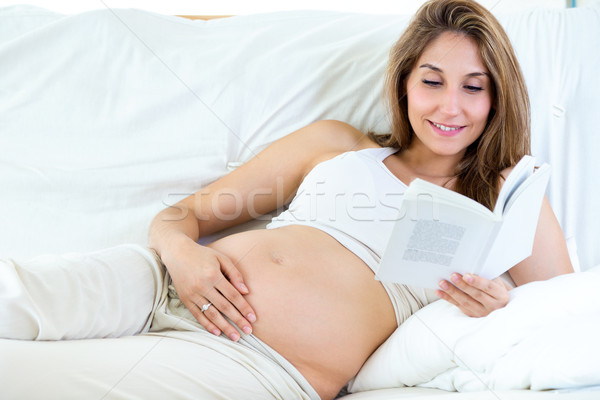 Pregnant woman reading a book on sofa. Stock photo © nenetus