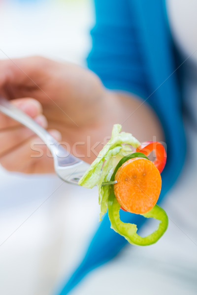 Joli jeune femme manger salade maison portrait [[stock_photo]] © nenetus