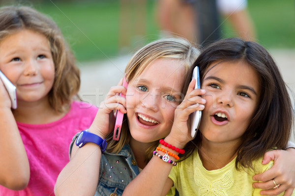 Group of childrens using mobile phones in the park. Stock photo © nenetus