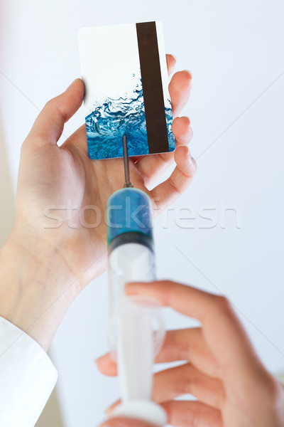 Woman hands injecting liquid into a credit card with a syringe. Stock photo © nenetus