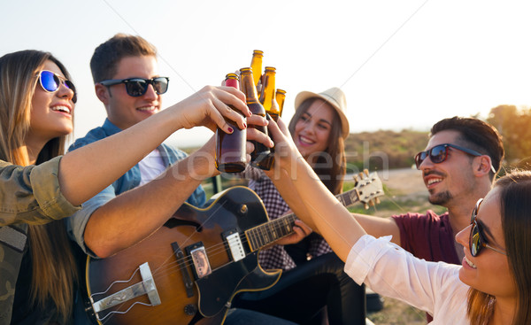 Portrait of group of friends toasting with bottles of beer. Stock photo © nenetus