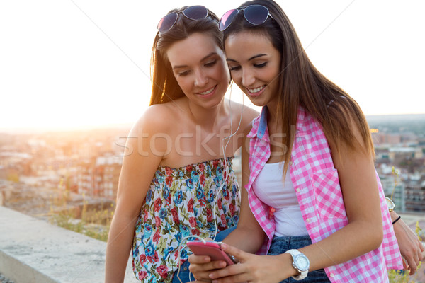 Beautiful girls sitting on the roof and listening to music at su Stock photo © nenetus