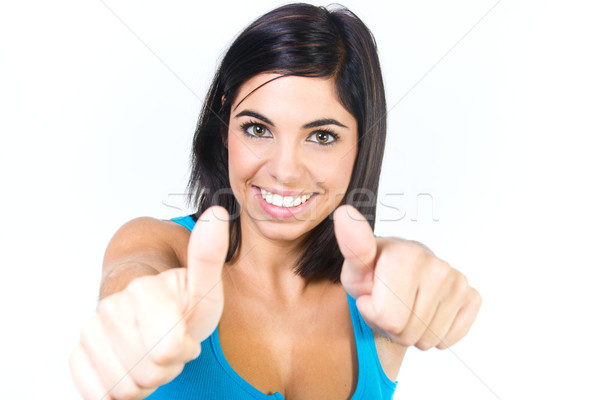 Excited young woman gesturing a thumbs up sign Stock photo © nenetus