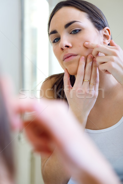 Woman caring of her beautiful skin on the face standing near mir Stock photo © nenetus