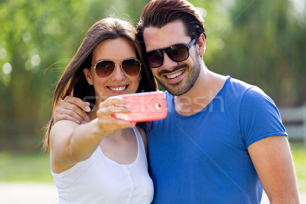 Happy young couple taking selfies with her smartphone in the par Stock photo © nenetus