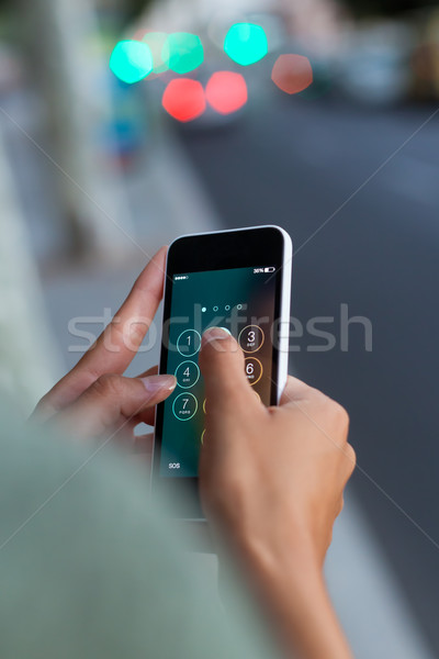 Mobile phone in a woman's hand in the city at night. Stock photo © nenetus